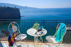 a table and chairs on a balcony overlooking the water at Mare Sunset & Relax in Meta