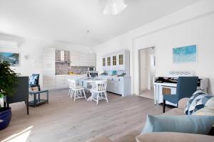 a kitchen and living room with a table and chairs at Mare Sunset & Relax in Meta