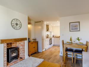 a living room with a fireplace and a dining room table at Knoll Cottage - Uk31171 in Brent Knoll
