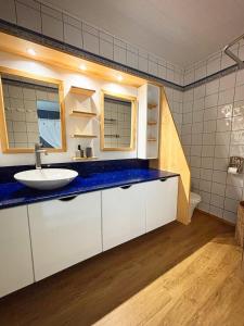 baño con lavabo y encimera azul en Villa Migaline, stunning bay views, en Le Marin