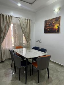 Un comedor con una mesa de cristal y sillas. en Jahi Apartments, en Kadobunkuro