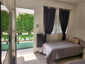 Un dormitorio con una cama y una ventana grande en Maktub Alta Gracia, Complejo para Turistas, en Alta Gracia