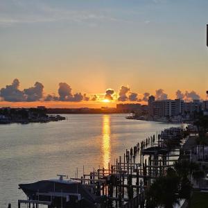 een zonsondergang boven een waterlichaam met een dok bij Clearwater Calm Condo in Clearwater Beach