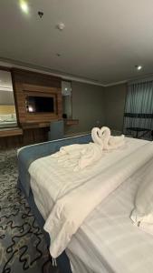 two swans sitting on a bed in a room at فندق الشهباء الفيحاء Hotel Al Shahba Al Faiha Jeddah in Jeddah