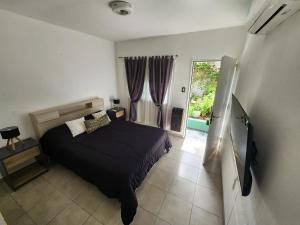 Un dormitorio con una cama y una ventana grande en Maktub Alta Gracia, Complejo para Turistas, en Alta Gracia