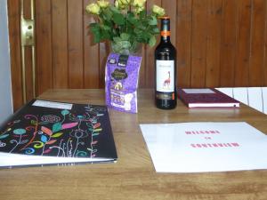 een fles wijn en een boek op een tafel bij Southview in Porchfield