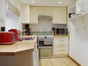 een keuken met witte kasten en een kookplaat oven bij Southview in Porchfield