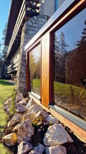 a window of a house with rocks in front of it at Rekreačné zariadenie Čingov - Slovenský raj in Spišské Tomášovce