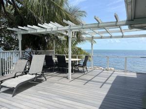 a deck with a table and chairs and the ocean at Caribbean Sunsets in Marathon