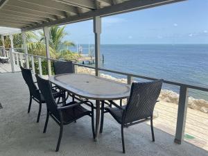 a table and chairs on a balcony overlooking the ocean at Caribbean Sunsets in Marathon
