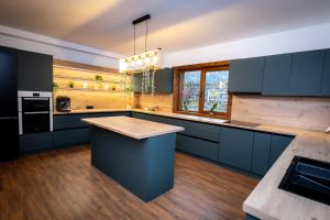 フンドゥ・モルドベイにあるChalet Sonnenhangのウッドフロアのキッチン(青いキャビネット付) +23枚の写真