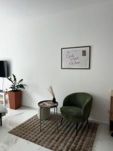 a living room with a green chair and a table at Patrinia in Vrijesno