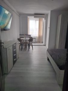 ein Zimmer mit Tisch und Stühlen und ein Schlafzimmer in der Unterkunft LaCriss in Hunedoara