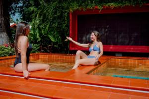 two women in bathing suits sitting in a swimming pool at Tolani Resort Koh Samui in Lamai