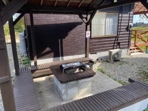 a patio with a grill and a brick building at 天然プラネタリウムcottage星空E棟 in Anazawa