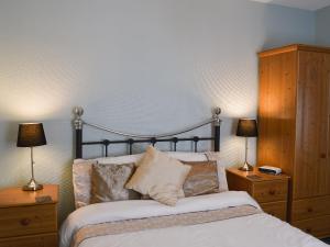 a bedroom with a bed with two night stands and two lamps at Blencathra House in Keswick