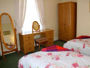 a bedroom with two beds and a dresser and a mirror at Blencathra House in Keswick +15 photos