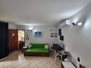 a living room with a green couch and a table at Apto Residencial Aconchego2 em Rio Quente Go - Hot Park in Rio Quente