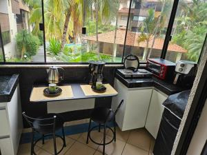 a kitchen with a table and chairs and a window at Apto Residencial Aconchego2 em Rio Quente Go - Hot Park in Rio Quente