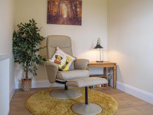 una silla en una habitación con una mesa y una planta en The Lookout - Uk35022, en Hope under Dinmore