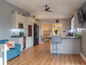 Una cocina y una sala de estar con un sofá azul. en The Lookout - Uk35022, en Hope under Dinmore