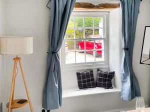 a window with blue curtains in a room at Dunmallet in Pooley Bridge