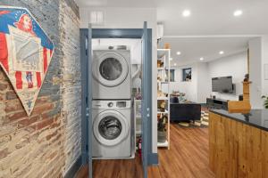 a washer and dryer in a room with a brick wall at 2BR Capitol hill delight, with private parking in Washington