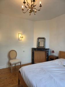 a bedroom with a bed and a mirror and a chair at Le Polygone in Le Mans