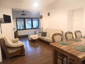 a living room with a table and a couch at Cazare La Cetate in Moşna