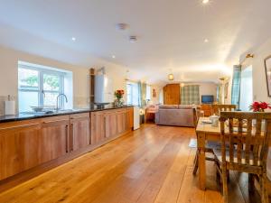 a kitchen with wooden cabinets and a living room at Long Barn - Uk30435 in Kingsbury Episcopi +8 photos