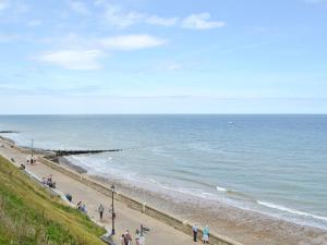 een groep mensen die langs een strand lopen bij Mayflower in Cromer +1 foto
