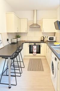 eine Küche mit einem Tisch und Stühlen darin in der Unterkunft Great for Contractors and Families 3BedHouse with FreeParking in Warrington