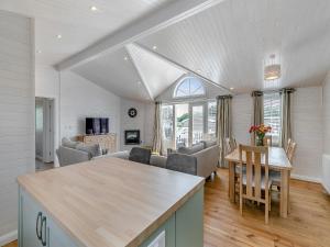 a kitchen and living room with a table and chairs at Fuchsia Lodge in Willington