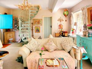 ein Wohnzimmer mit einer Couch und einer Treppe in der Unterkunft Kipling Cottage in Burwash