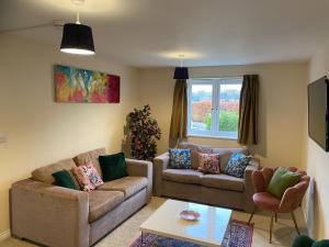 a living room with two couches and a table at Warm & Cosy 4 Bed Cambridge House w Parking Garden & High Speed WIFI in Milton