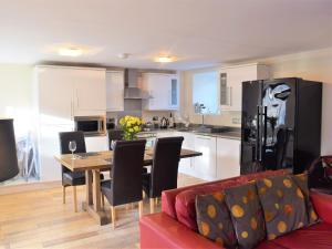 a kitchen and living room with a table and a couch at Annie Oswalds Cottage in Lucker