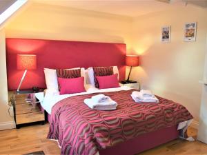 a bedroom with a large bed with a red headboard at Annie Oswalds Cottage in Lucker +11 photos