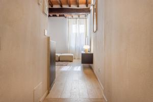 an empty hallway with a room with a table at Nebbia sul Naviglio - Rua Frati 34 - Boutique Apartment in Modena