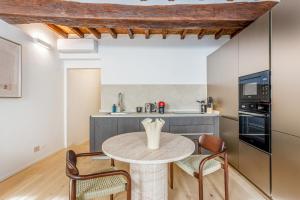 a kitchen with a table and chairs in a room at Nebbia sul Naviglio - Rua Frati 34 - Boutique Apartment in Modena