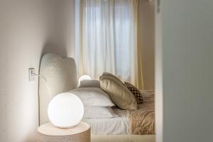 a bedroom with a bed with pillows and a lamp at Fumo di Lambrusco - Rua Frati 34 - Boutique Apartment in Modena