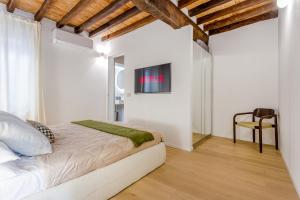 a bedroom with a bed and a tv on the wall at Fumo di Lambrusco - Rua Frati 34 - Boutique Apartment in Modena