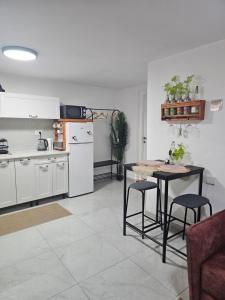 a kitchen with white cabinets and a table and chairs at Panda house by the sea in Qiryat Yam