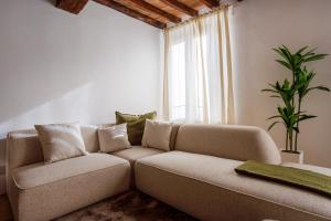 a living room with a couch and a window at Fumo di Lambrusco - Rua Frati 34 - Boutique Apartment in Modena +9 photos