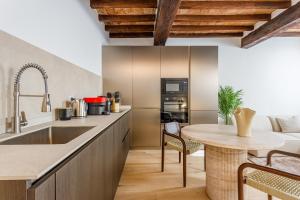 a kitchen with a sink and a table in a room at Nebbia sul Naviglio - Rua Frati 34 - Boutique Apartment in Modena +12 photos