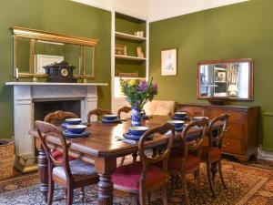 a dining room with a table with chairs and a fireplace at Hillside House in Kirkby Lonsdale