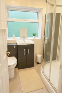 ein Badezimmer mit Toilette und Waschbecken und einem Fenster in der Unterkunft Great for Contractors and Families 3BedHouse with FreeParking in Warrington