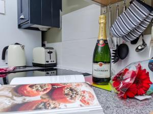 een fles wijn en een doos met eten op een aanrecht bij Bailey's Barn in Bonsall