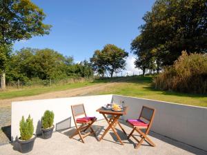 zwei Stühle und ein Tisch auf einer Terrasse in der Unterkunft Lower Bushford Cottage in Talbenny