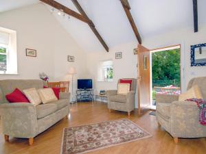 ein Wohnzimmer mit zwei Sofas und einem Fernseher in der Unterkunft Lower Bushford Cottage in Talbenny