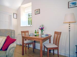 ein Esszimmer mit einem Tisch und 2 Flaschen Wein in der Unterkunft Lower Bushford Cottage in Talbenny